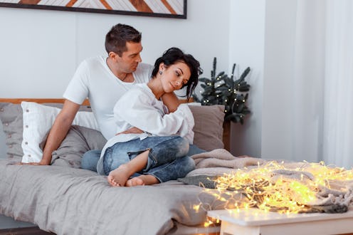attractive man and woman hugging on the bed. couple cuddling near