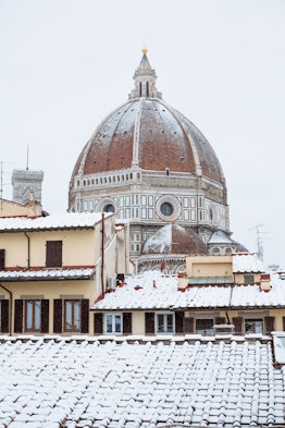 The Duomo in Florence, Italy is covered in snow around Christmastime.