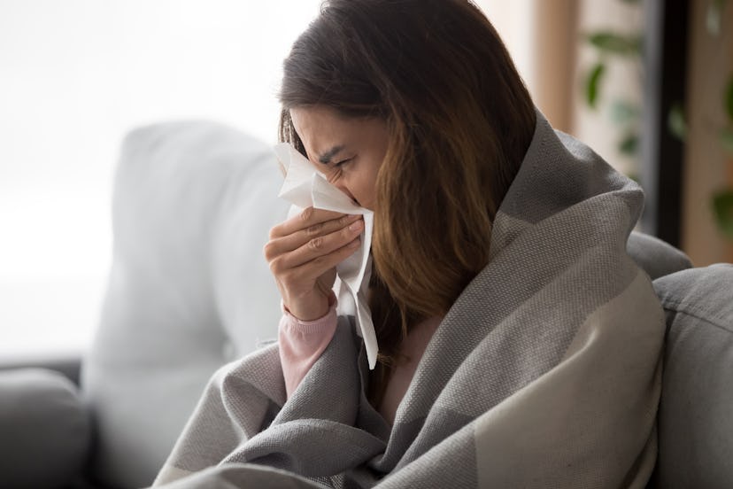 This woman blowing her nose could be staying home from work because of the flu. 