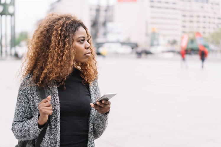 Woman holding phone, possibly cutting ties with someone she is in love with but can't be with.