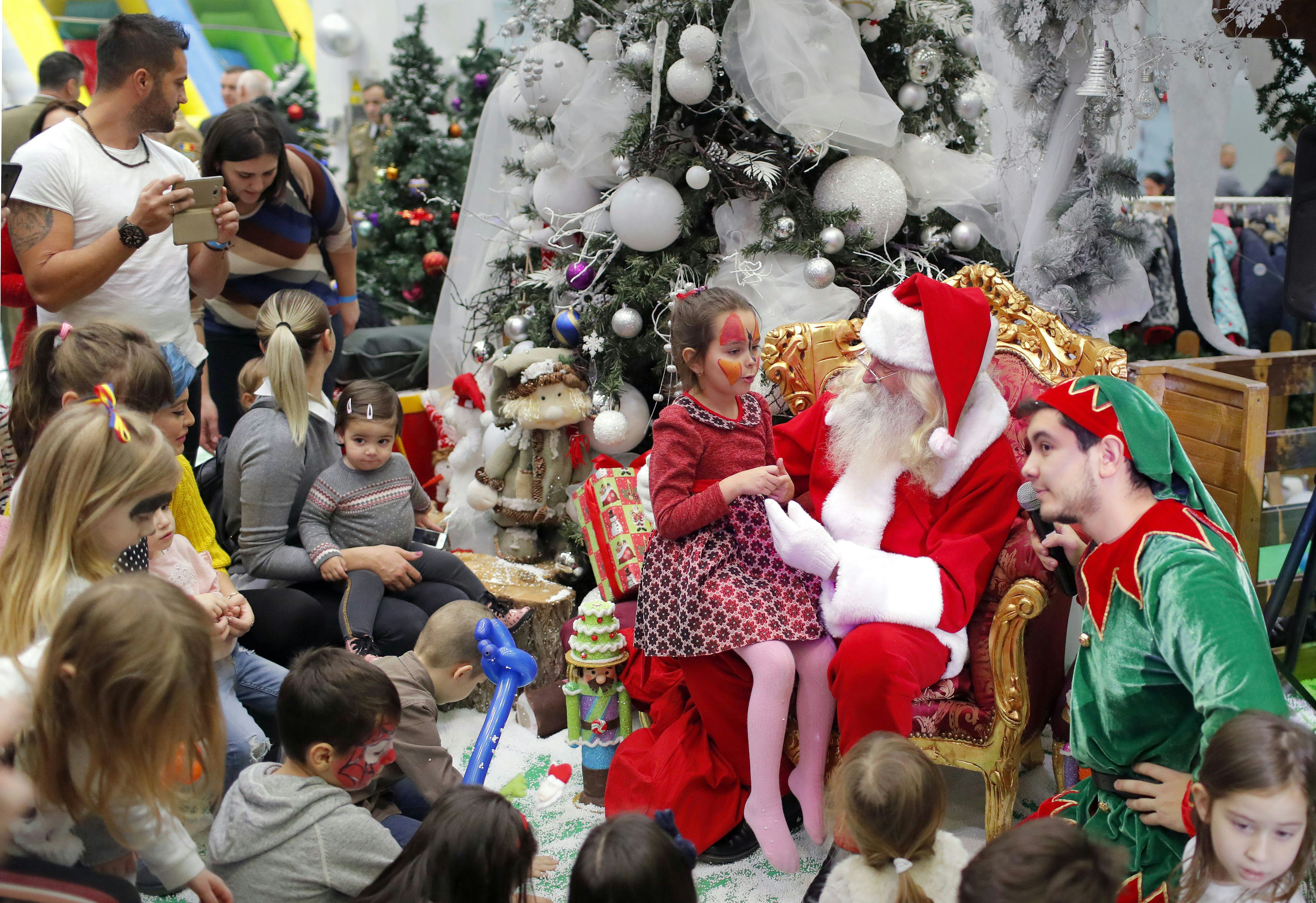 Children wait for their turn to the Santa gift moment while attending a Christmas Tree show dedicate...