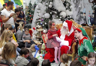 Children wait for their turn to the Santa gift moment while attending a Christmas Tree show dedicate...