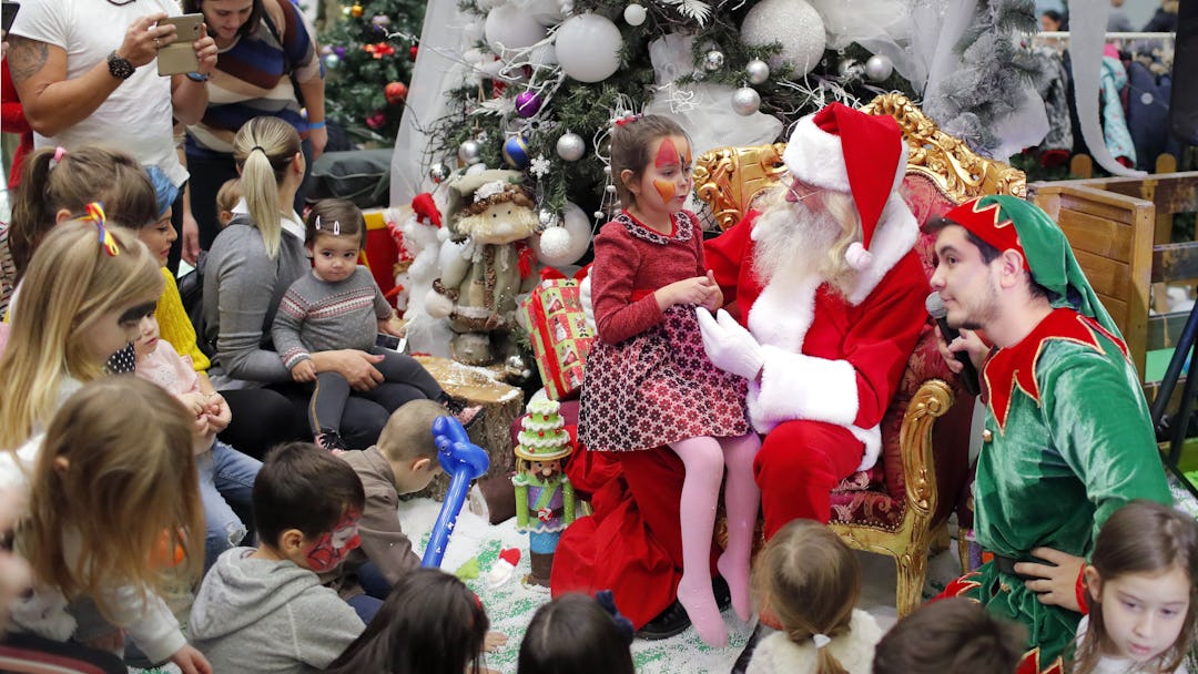 Children wait for their turn to the Santa gift moment while attending a Christmas Tree show dedicate...