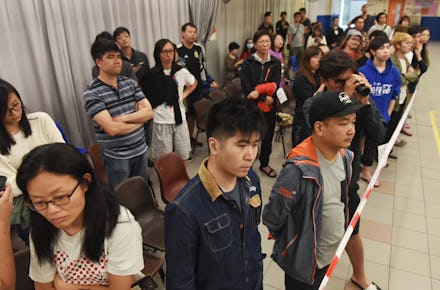 Residents and voters witness the vote counting at a polling station