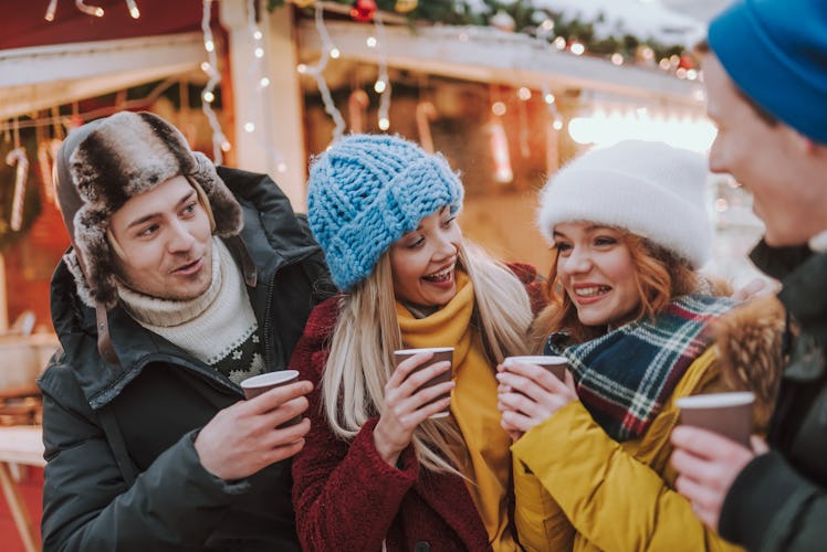 Having fun. Cheerful blonde girl turning her head while talking to her friend