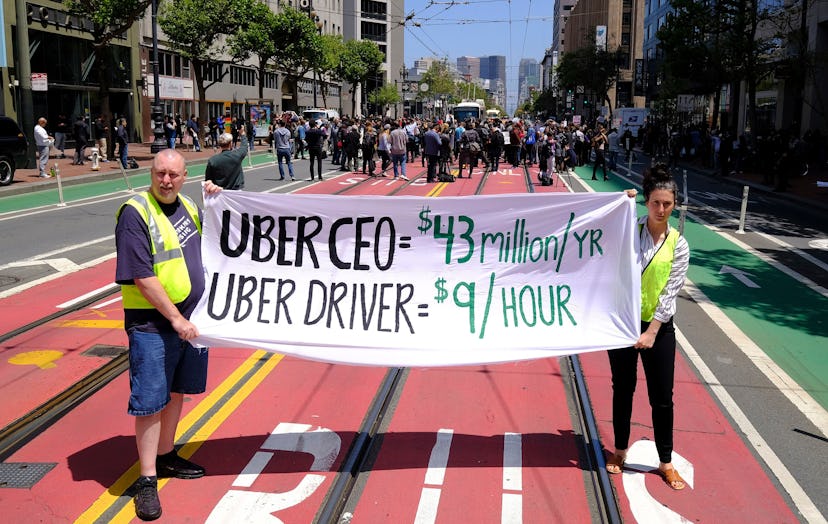 Protesters stop traffic on Market Street during a demonstration outside of Uber headquarters, in San...