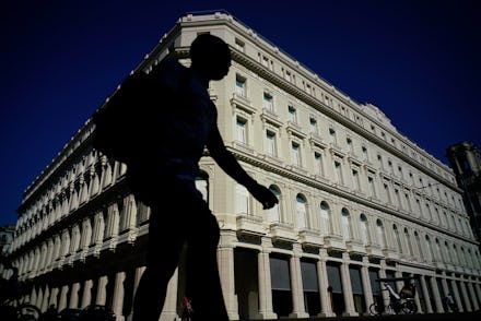 A man walks in front of the Manzana de Gomez Kempinski five-star hotel in Havana, Cuba. Five months ...