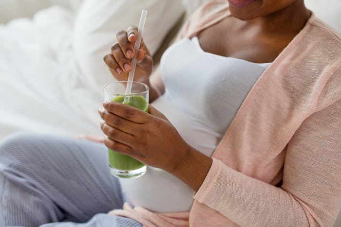 pregnant woman sipping a smoothie