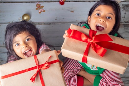 Little sisters opening their gifts on Christmas day