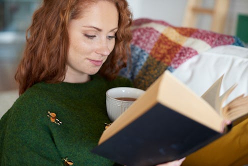 Smiling woman reading book in winter day