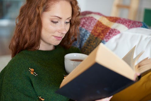 Smiling woman reading book in winter day 