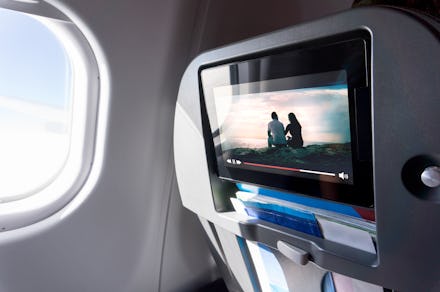 Watching movie on an airplane touch screen. Imaginary film playing on a video player in monitor duri...