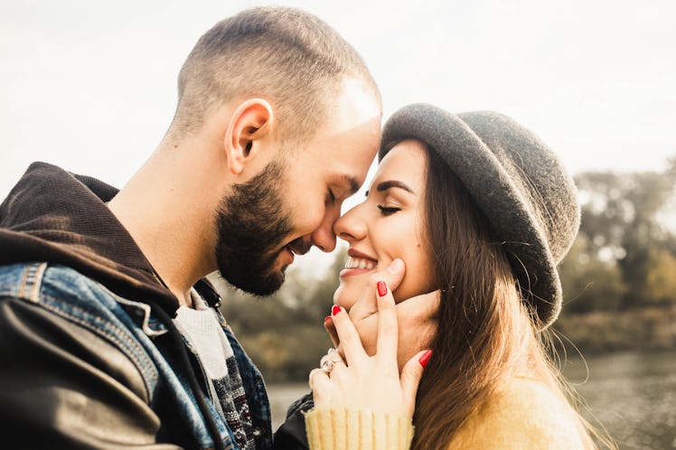 Lovely couple. Girl in hat close eyes. Boyfriend hugging her face. Romantic day. Outdoor. Cozy love....