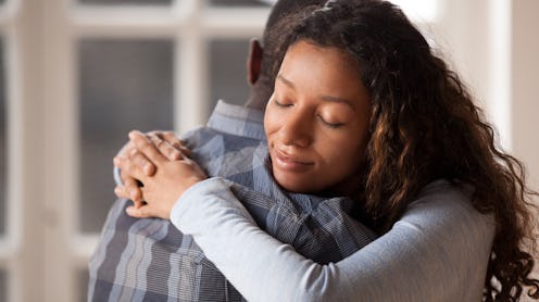 Happy mixed race woman hug black man husband glad to make peace after fight, loving young girlfriend...