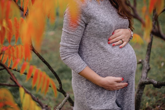 a girl hugging her pregnant belly on the 9th month 