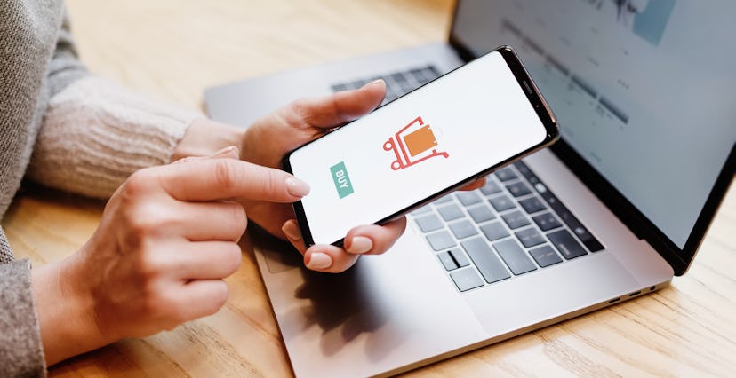 Woman with phone. Online payment. Women hands using smartphone and laptop computer for online shoppi...