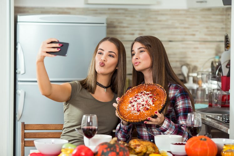 Two brunette girls take a selfie with their sweet potato pie on Thanksgiving. 