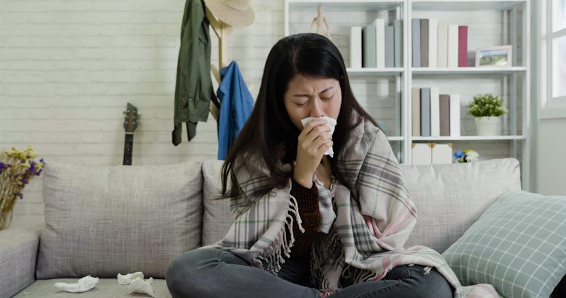 sick woman coughing with tissue in hands cover mouth. illness asian female sneezing running nose usi...