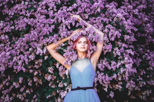 Beautiful girl with pink hair, enjoying the Lilac garden. cheerful teenager walking in the fresh air...