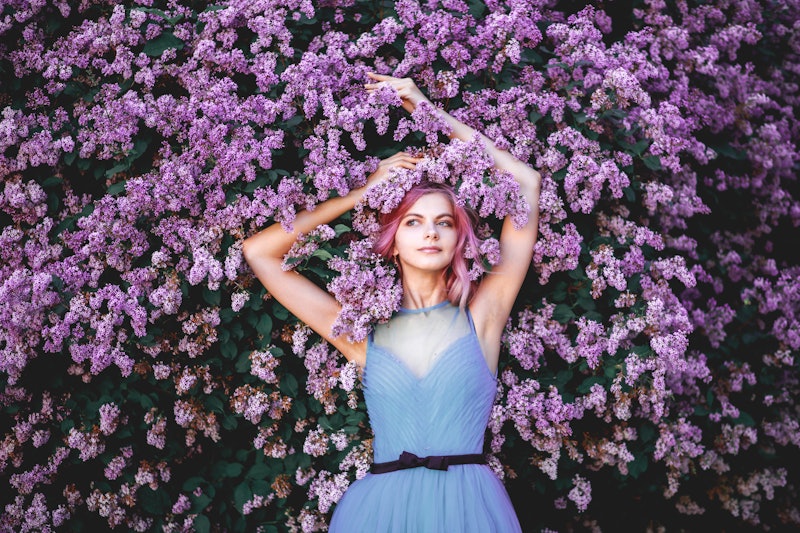 Beautiful girl with pink hair, enjoying the Lilac garden. cheerful teenager walking in the fresh air...