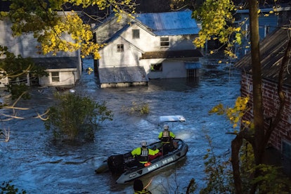 In this photo provided by the New York State Governor's Office, a man looks from a window of a house...