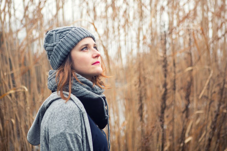 portrait of young woman outdoors in the cold with reeds in the background