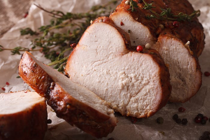 Delicious homemade baked sliced turkey close-up on paper. Horizontal