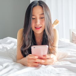 Yound woman using smart phone on the bed 