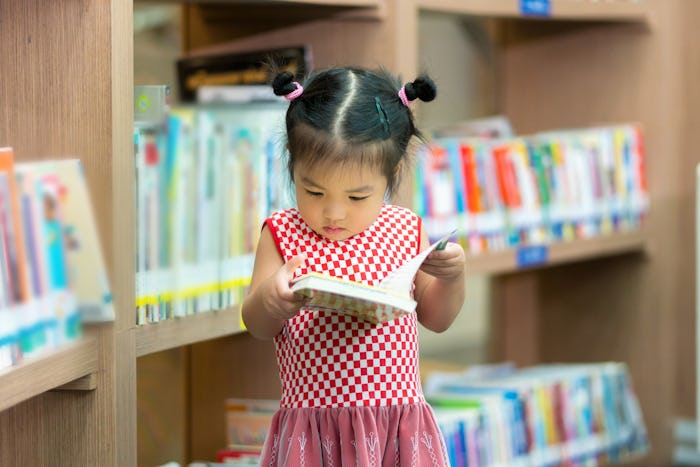 A little girl reading a book in a bookstore