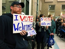 Residents in support of continued refugee resettlement hold signs at a meeting in Bismarck, N.D., Mo...