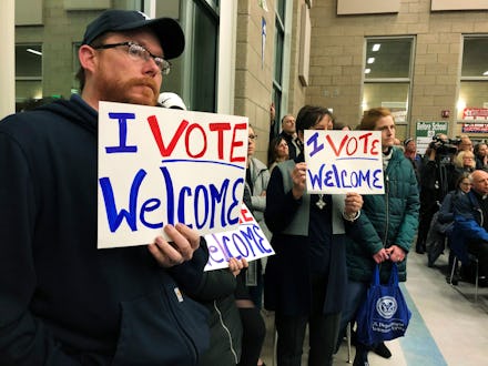 Residents in support of continued refugee resettlement hold signs at a meeting in Bismarck, N.D., Mo...