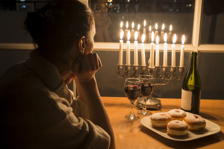 Low key Image of jewish holiday Hanukkah (holiday of lights) with menorah, burning candles, donuts a...