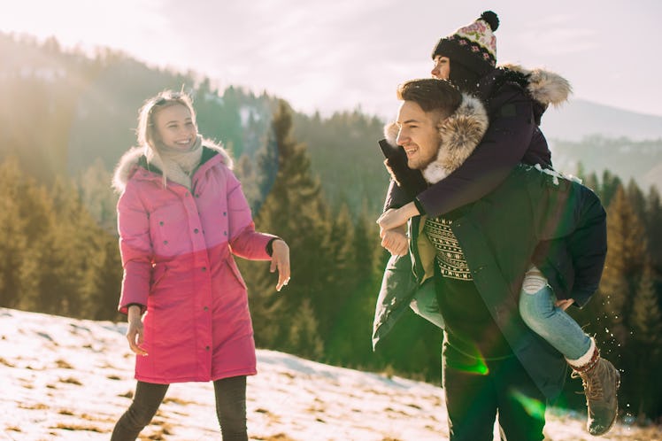 Three friends laugh and have fun outside on a winter vacation for the holidays.