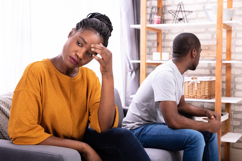 Upset Young African Couple Sitting On Sofa Ignoring Each Other