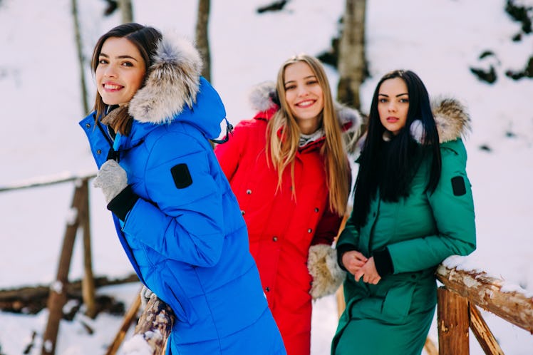 three cheerful young women in winter mountains