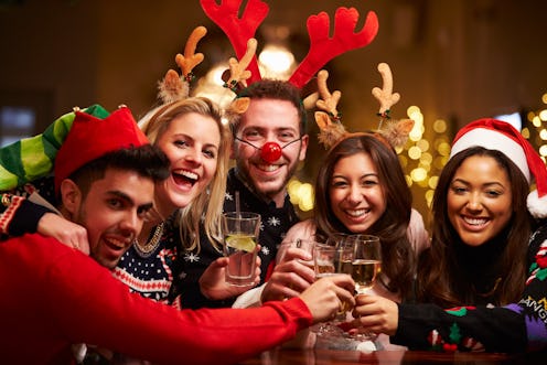 A group of friends dressed up for Christmas toast in a bar during SantaCon.