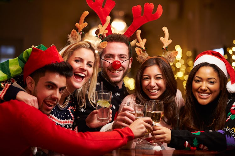 A group of friends dressed up for Christmas toast in a bar during SantaCon.