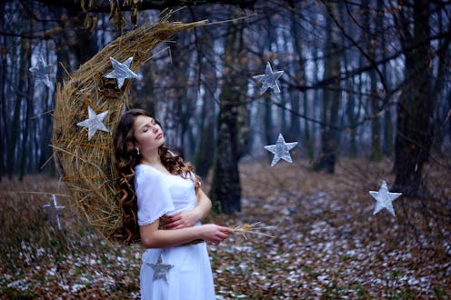 Beautiful young girl with brown curly hair. White dress on the perfect figure of the model. Month, h...