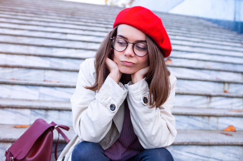 sad woman in glasses sitting on the stairs