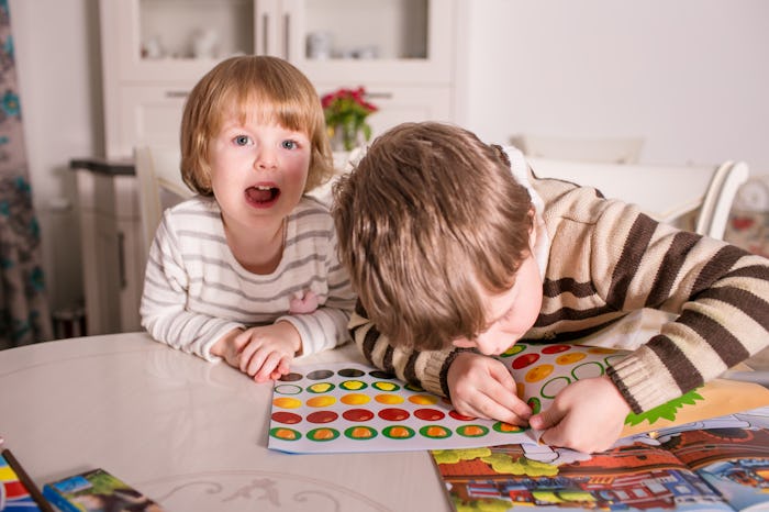 two kids playing with sticker books