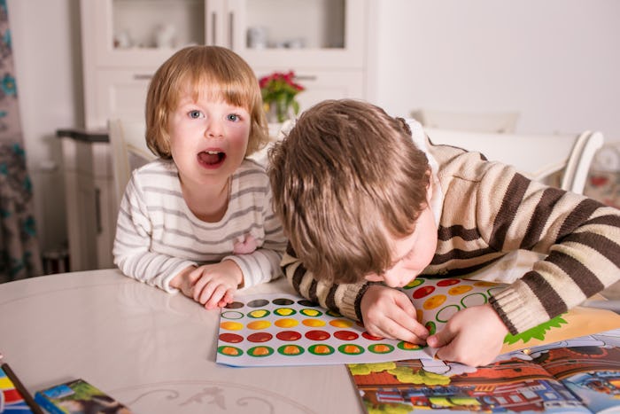 two kids playing with sticker books