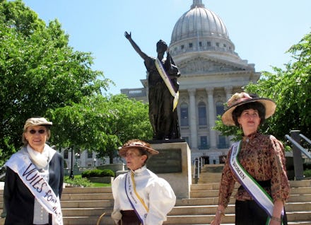 Women dressed in clothing styles from 1919 gather outside of the Wisconsin state Capitol on to comme...