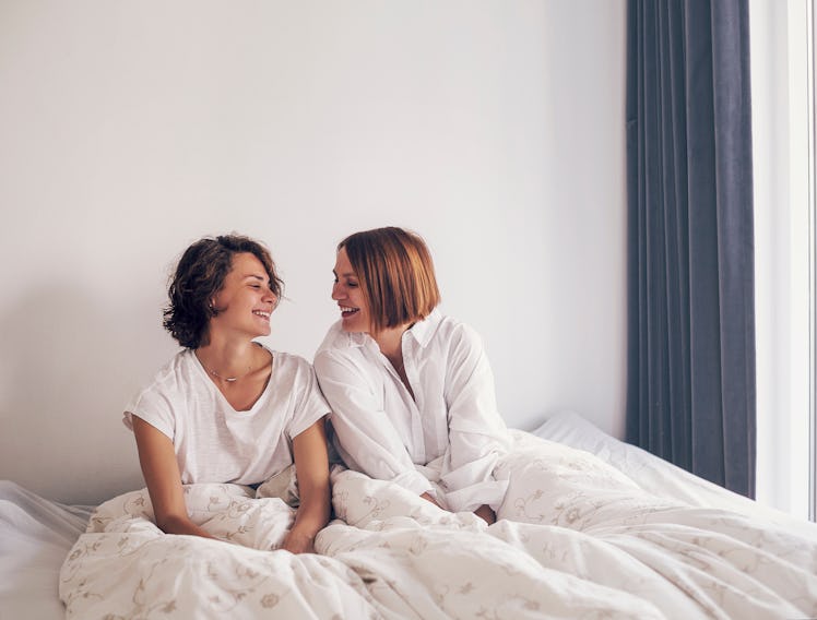 Two beautiful yuong women sleeping on bed together. Lesbian lovers and couple concept. People and l...