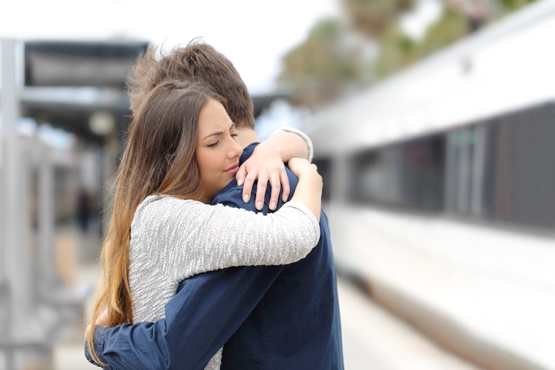 Sad couple hugging saying goodbye before train travel