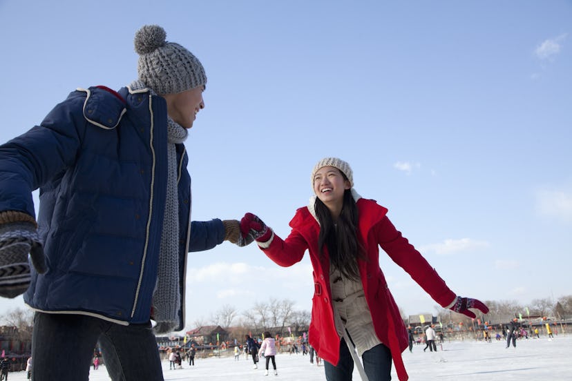 Young couple skating at ice rink. A great holiday activity 