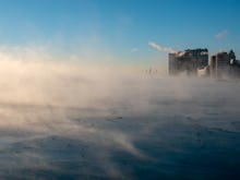 Chicago skyline in the distance from the far north lakefront on a frigid morning over a steaming lak...