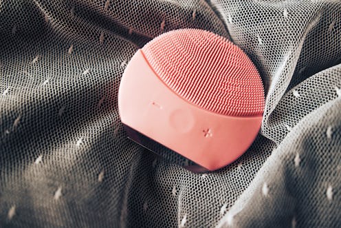 top view of pink silicone cleansing facial brush. Facial cleansing device