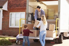 Family Unpacking Moving In Boxes From Removal Truck