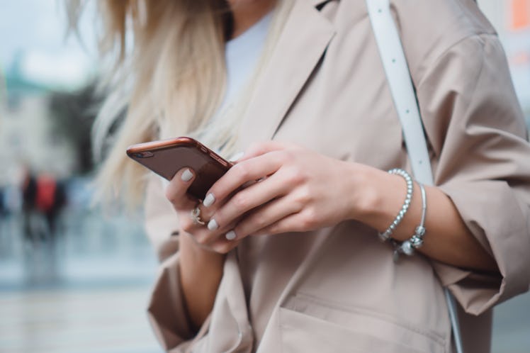 Close up of women's hands holding cell telephone with blank copy space scree for your advertising te...