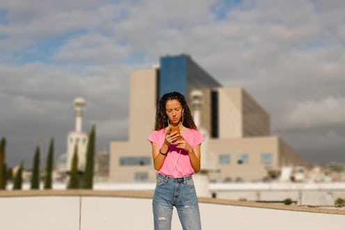 woman texting a message on the phone on a urban environment